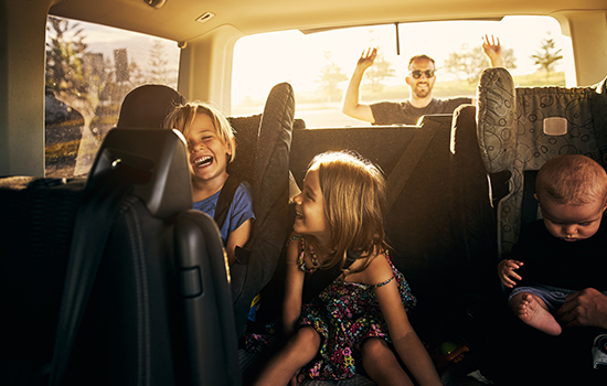 Features Image - family in car with hands raised in joy